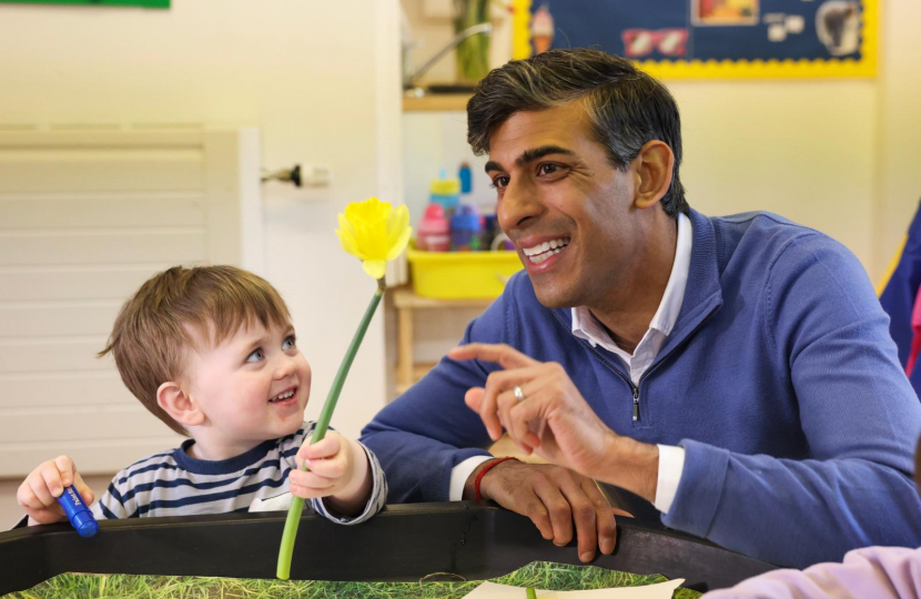 Prime Minister Rishi Sunak smiles as he plays with child in nursery